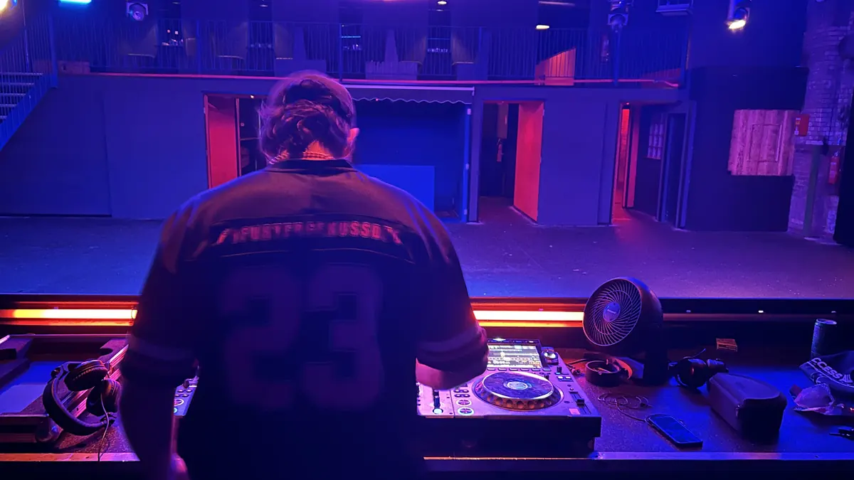 Blick über Flos Schulter auf das DJ-Pult und die Tanzfläche